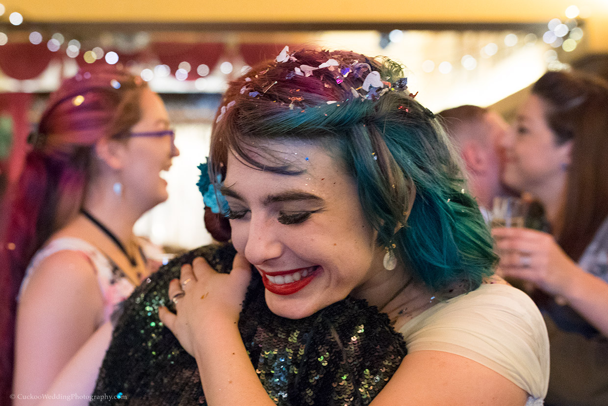 Bride hugs friend during documentary coverage of the drinks reception at their Asylum Chapel wedding